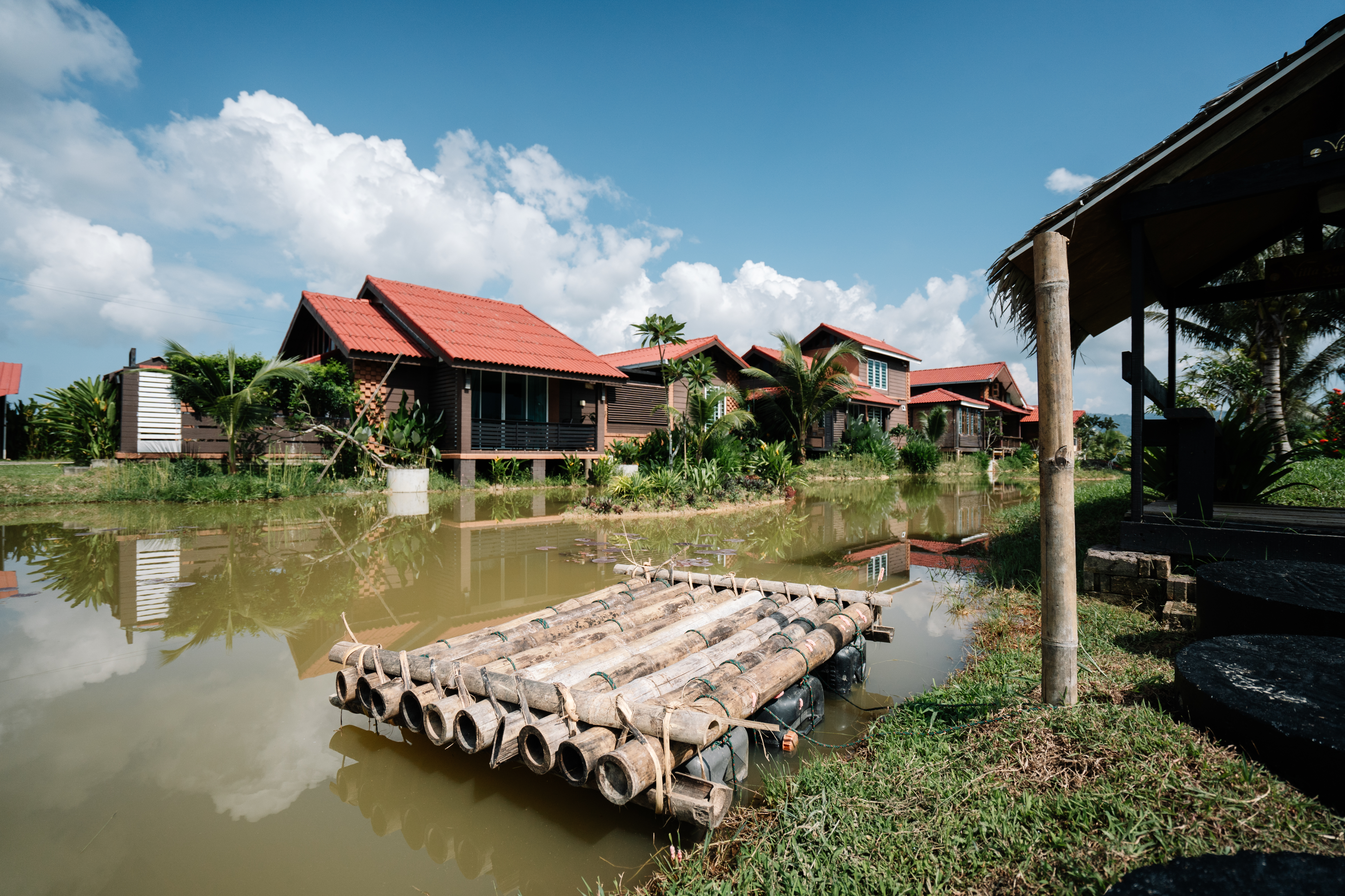 Villa Sawah homes beside the pond with bamboo raft and blue sky